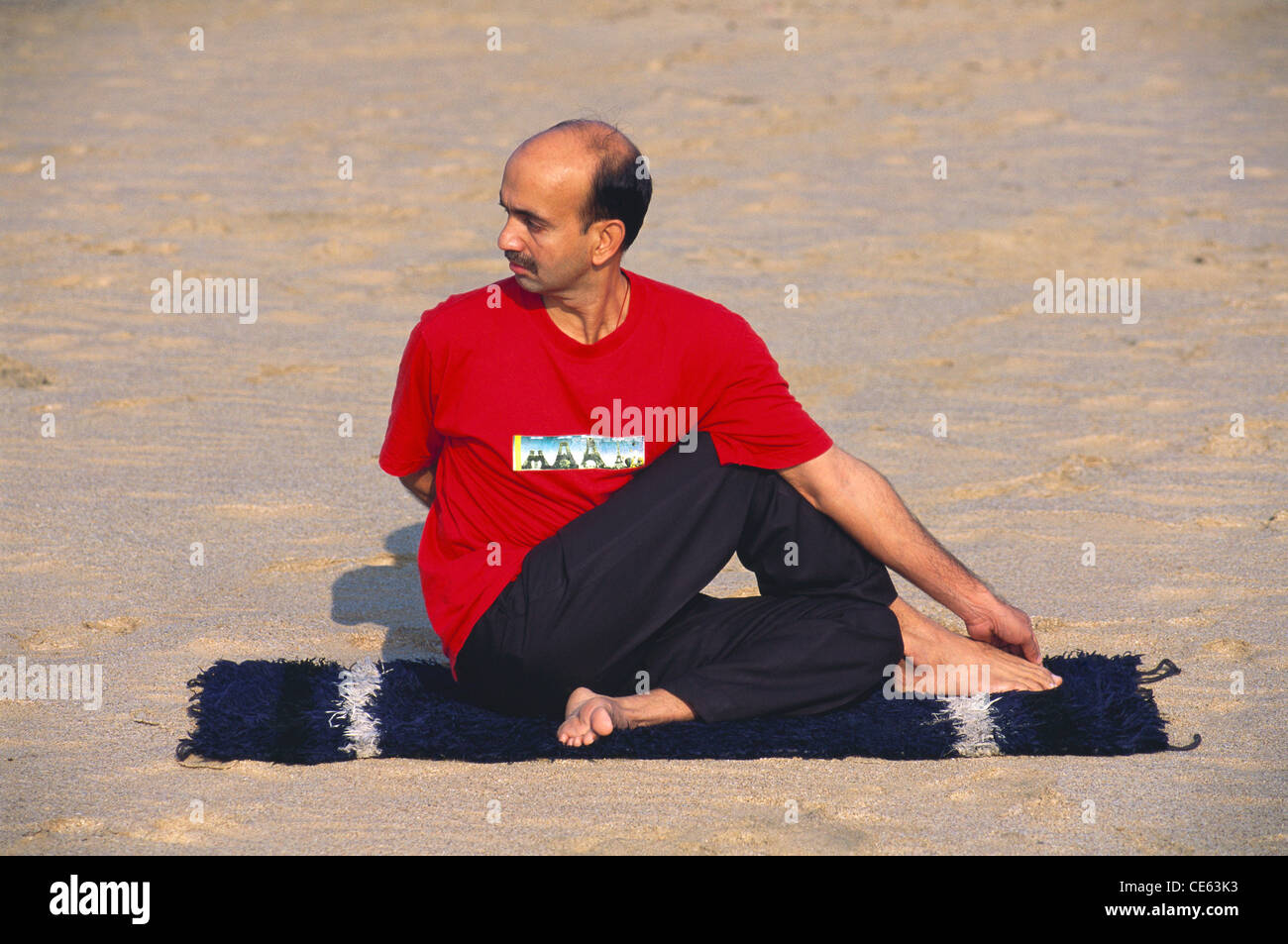 Indian man showing yoga exercise posture Ardha Matsyendrasana ; Matsyendrasana ; Fish pose ; India ; Asia ; MR#672 Stock Photo