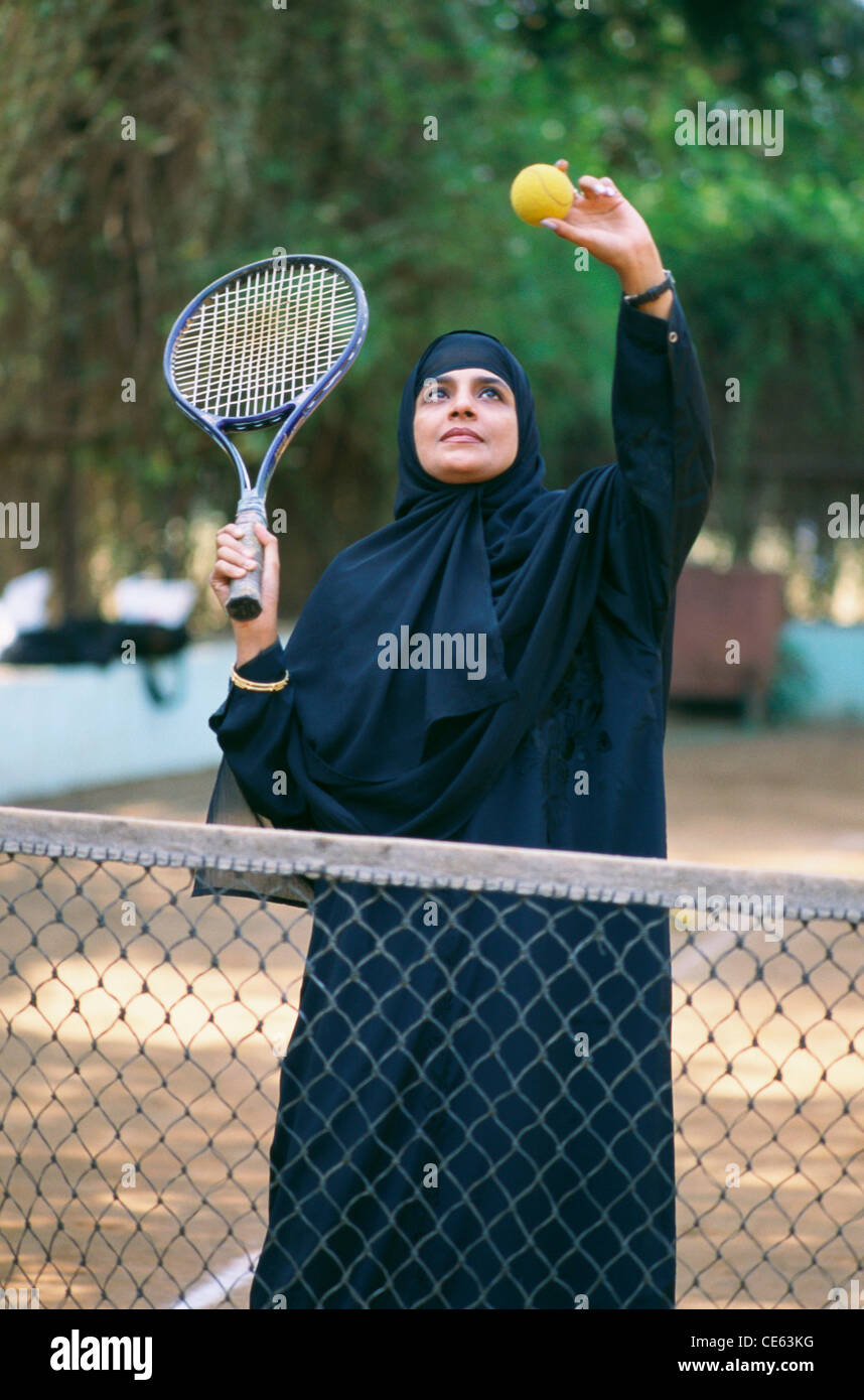 Indian Muslim woman wearing burqa or burka or burkha playing tennis