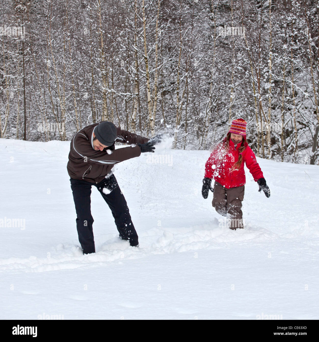 Father and daughter make a snowball fight in the snow Stock Photo