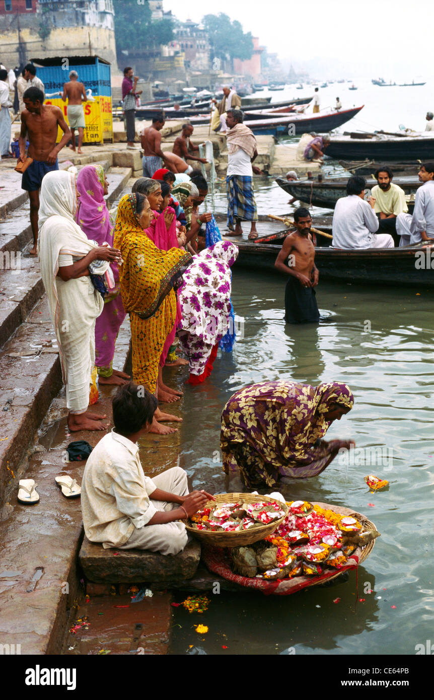 Flower vendor selling marigold flowers for worship by people bathing in