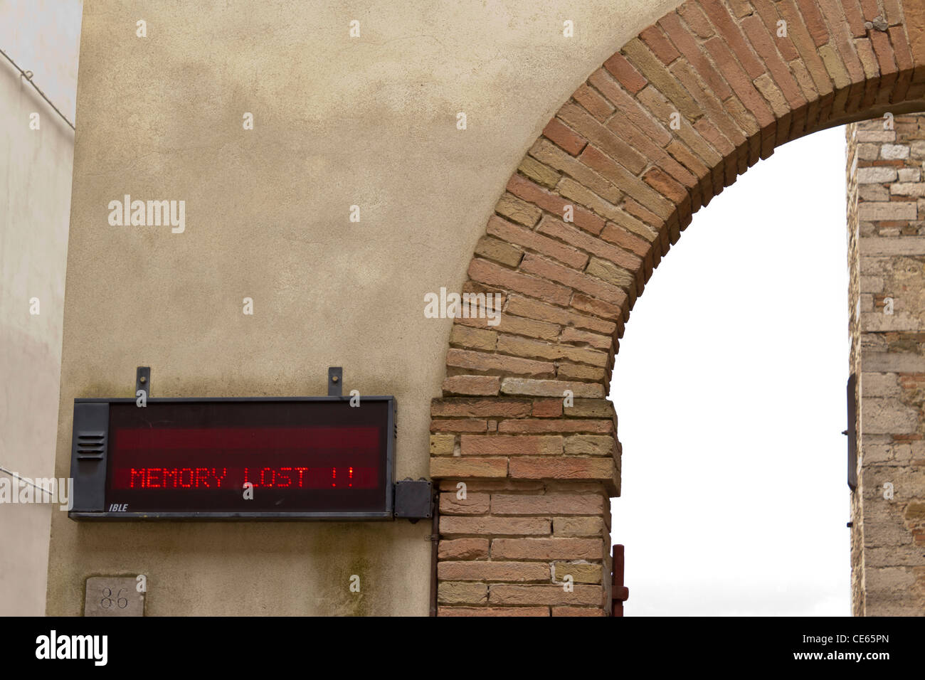 Medieval archway with malfunctioning modern electronic sign in Perugia, Italy Stock Photo