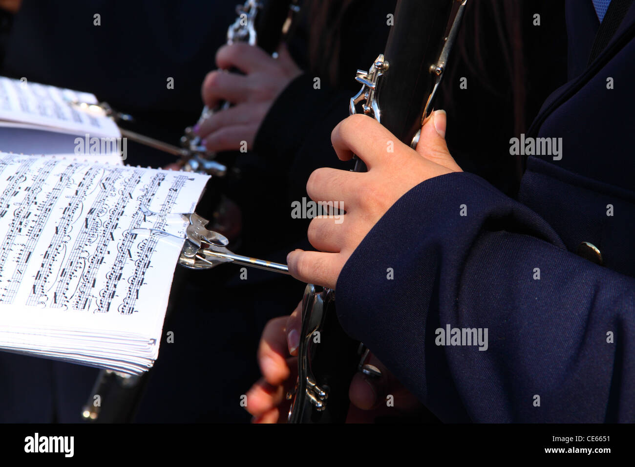 A musician is playing a clarinet following a musical score Stock Photo