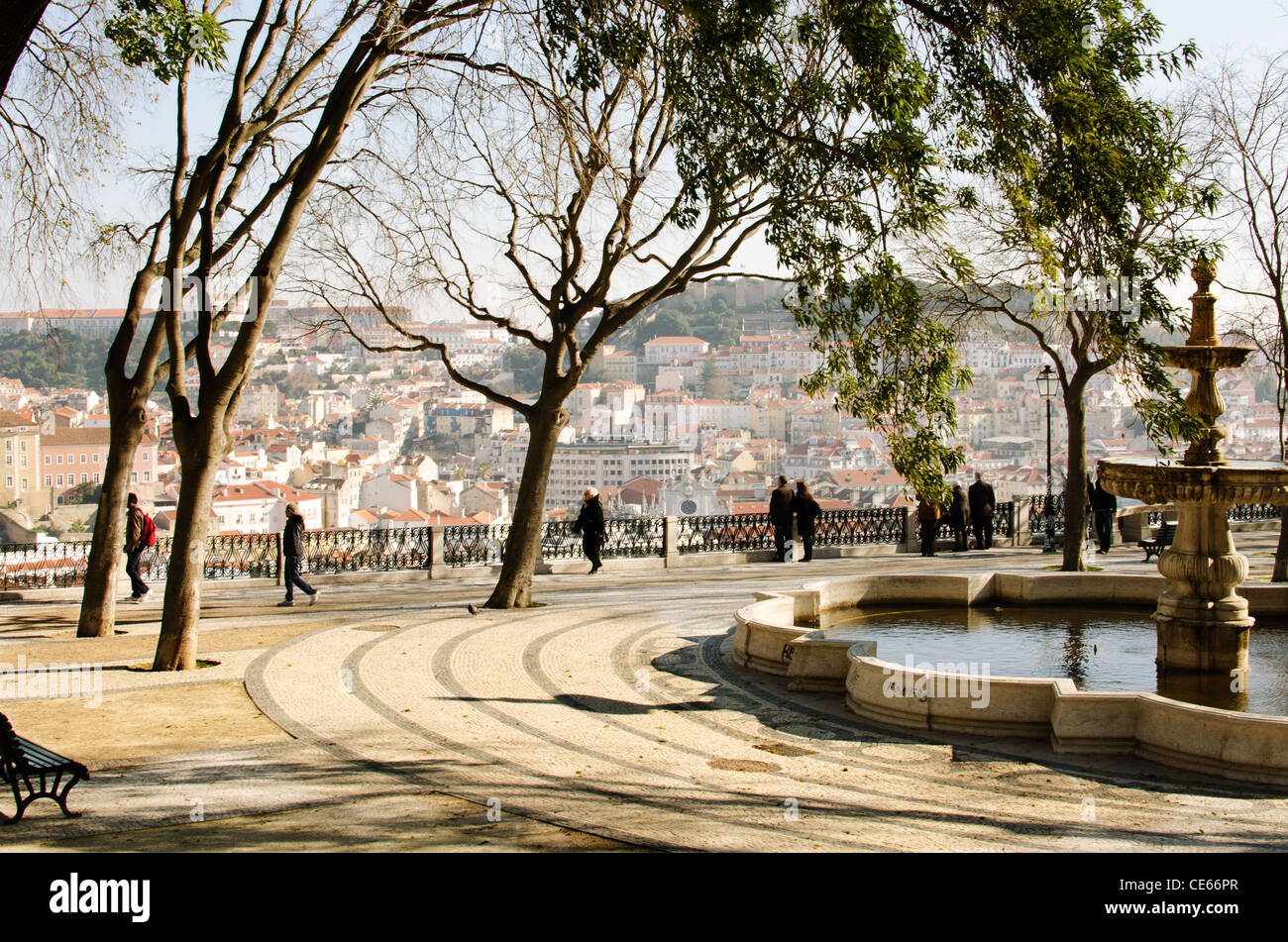 Tourists have a view at a sunny Lisbon. This peaceful square shows us a remodelled Lisbon, yet empty from its inhabitants Stock Photo