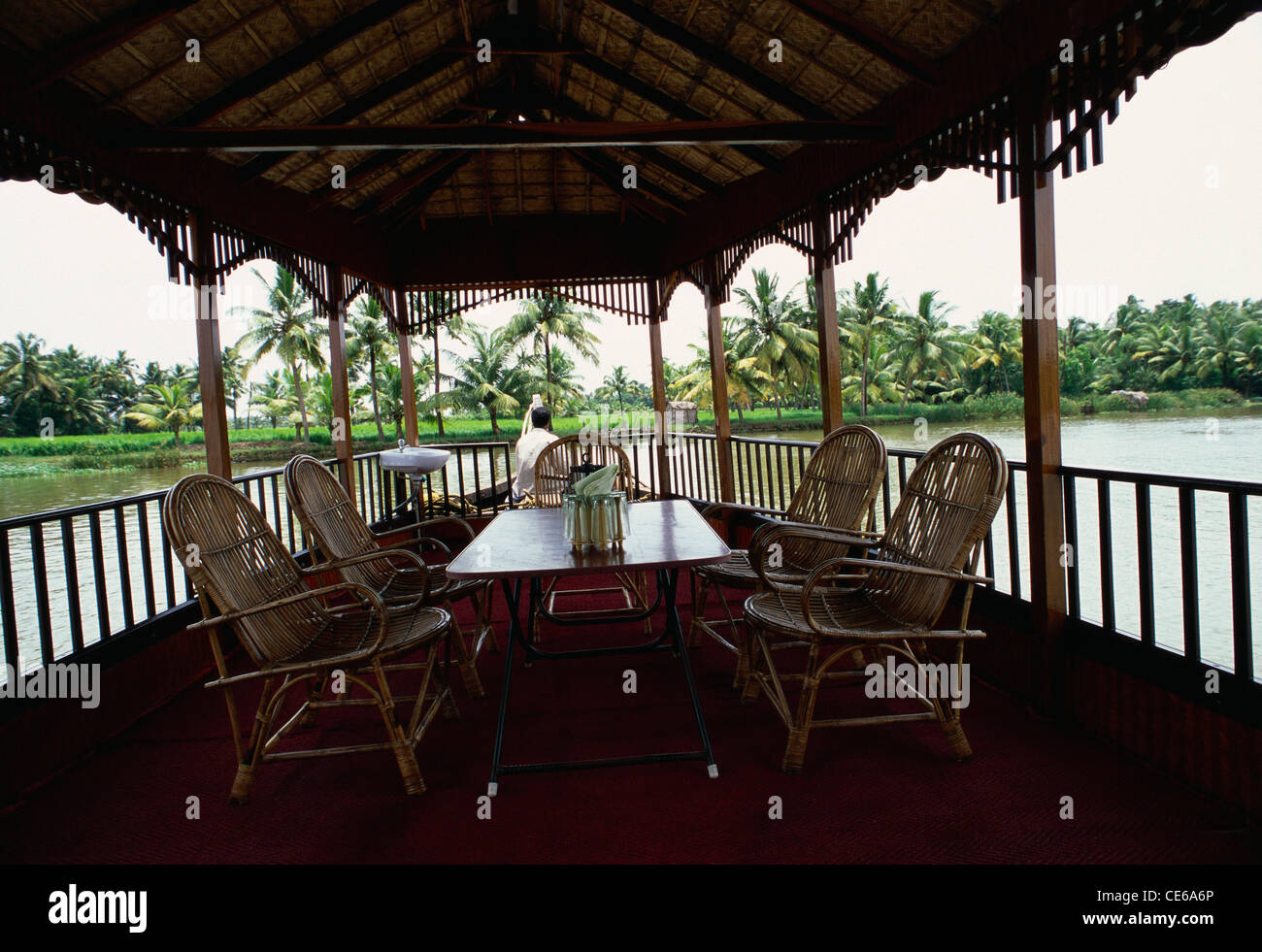 four cane chairs and dining table in house boat Kettuvallom Kerala