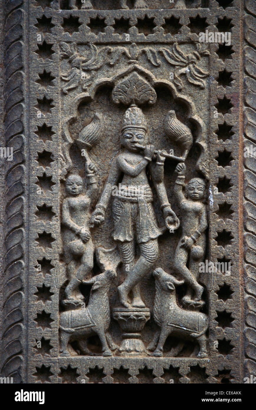 lord Krishna playing flute stone relief carving temple wall narmada