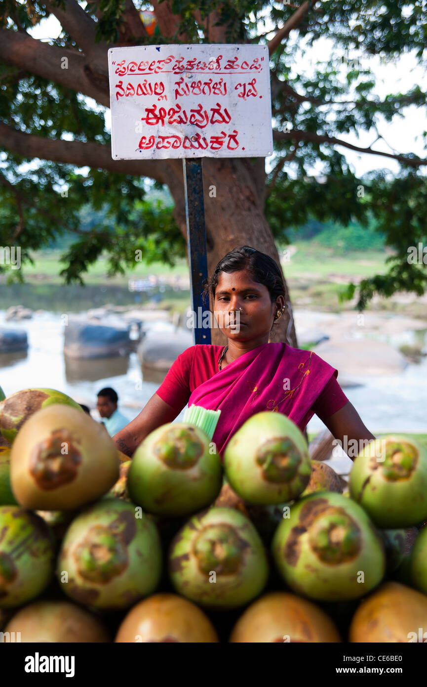 Coconut seller at the banks of Tungabhadra river, Hampi, Karnataka, India. Stock Photo
