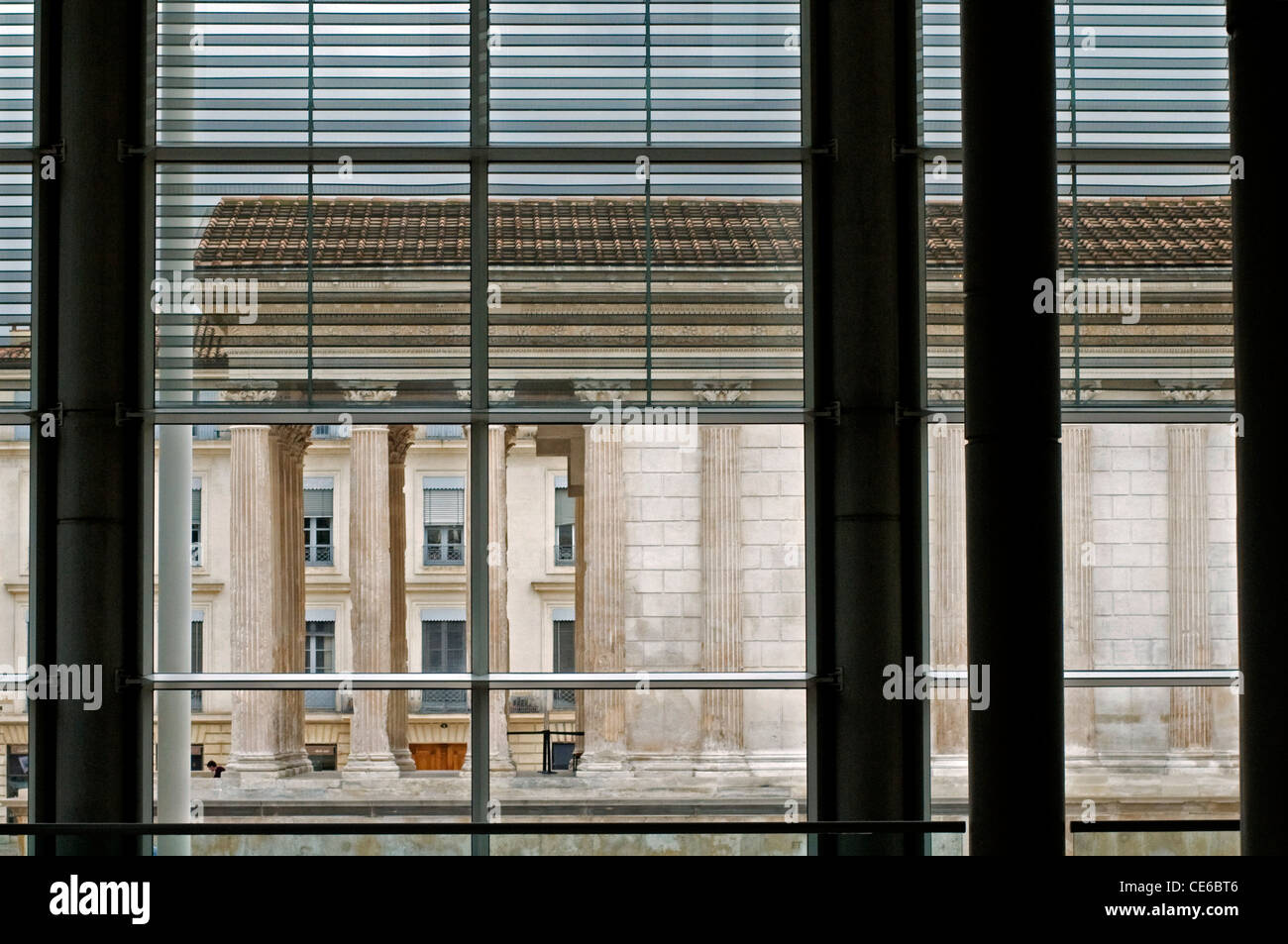 View of the Maison Carrée in Nimes through the windows of the Musée Carré d'Art Stock Photo