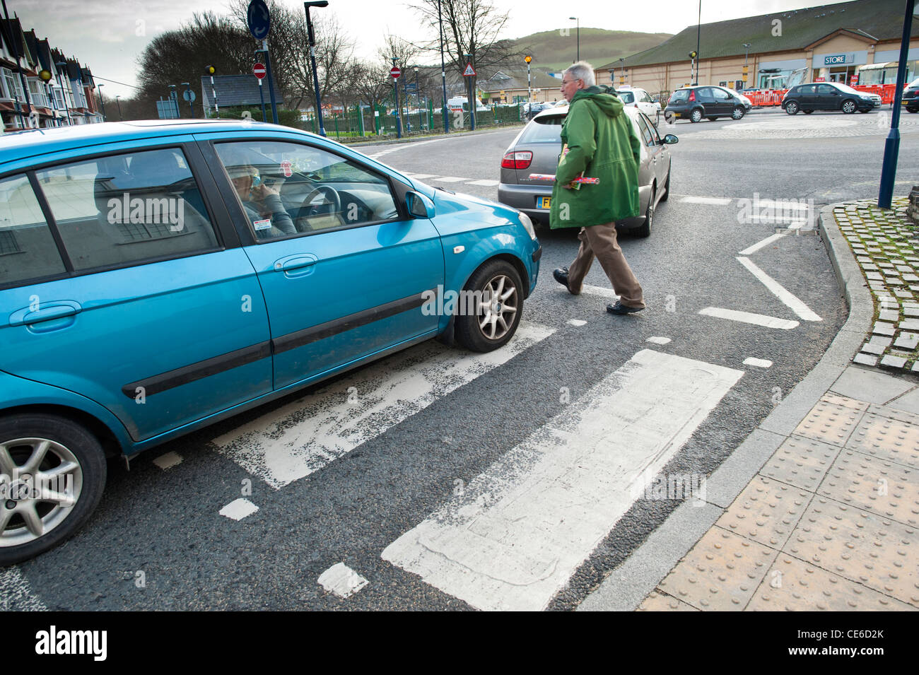 Bad roving: A car obstructing a pedestrian walking across a zebra crossing, UK Stock Photo