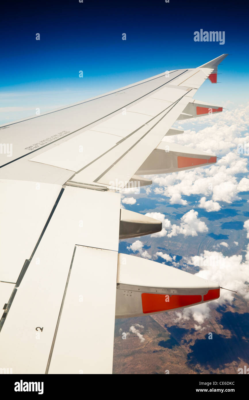 View of jet aircraft wing above the clouds. Stock Photo