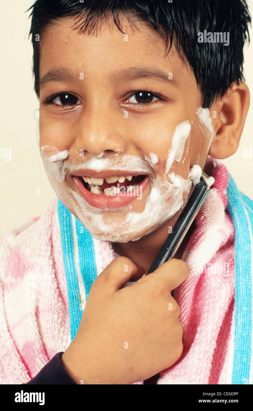 Kids Using Razors small young boy pretending acting to shave like father with razor India ...