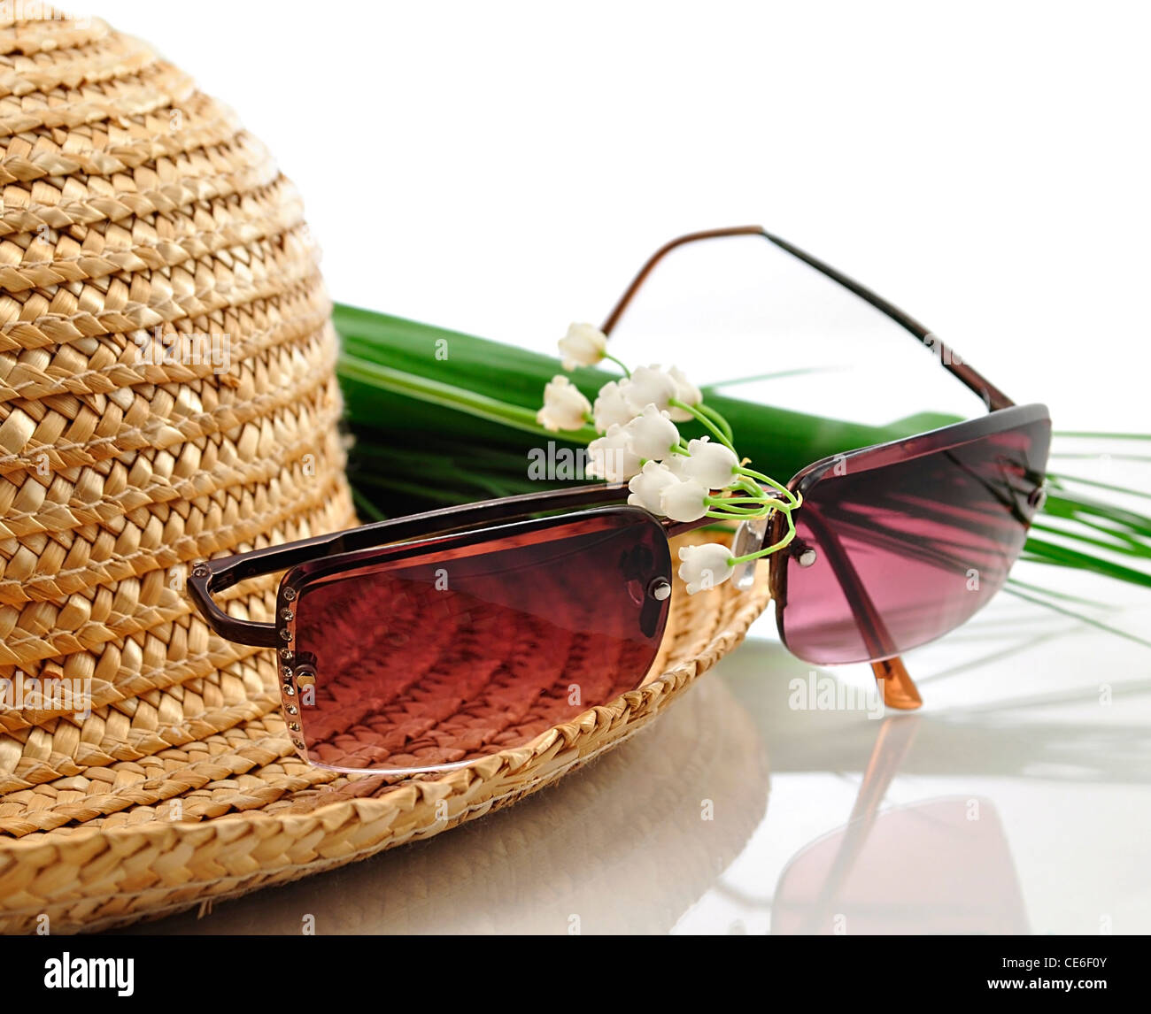 a straw hat with sunglasses and flowers Stock Photo - Alamy