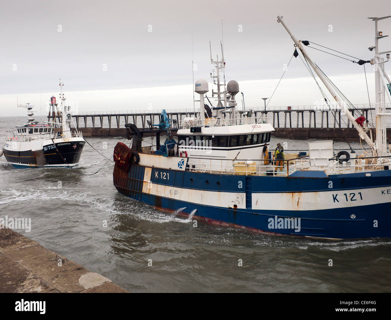 A crab fishing boat Noronya being towed into Whitby harbour for repairs by trawler Keila both boats from Kirkwall Orkney Stock Photo