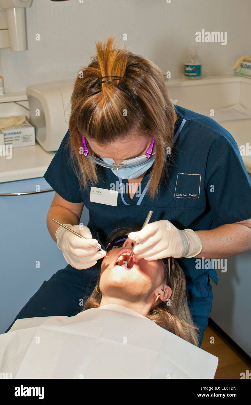 dental hygenist cleaning teeth chair dentist clean hygene checking check up female girl caucasian white check up Stock Photo