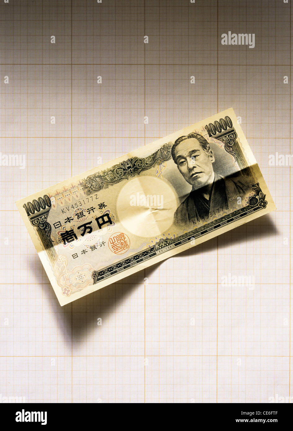 UNFOLDED 10,000 JAPANESE YEN BANKNOTE ON GRAPH PAPER Stock Photo