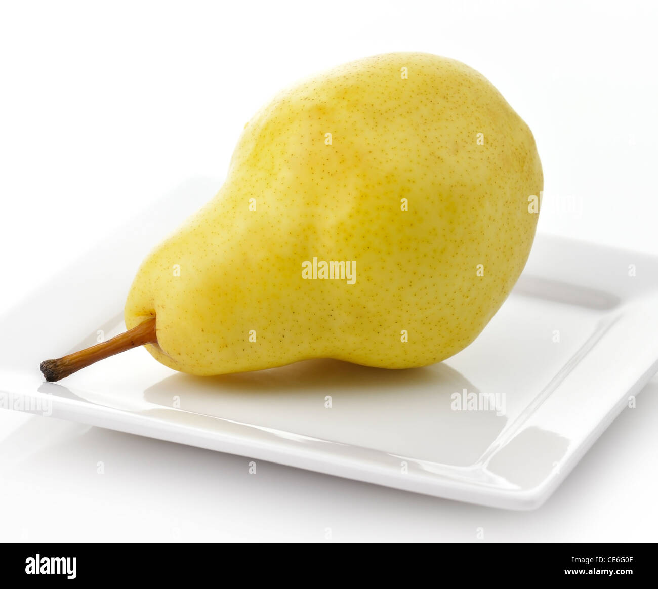 A Yellow Pear On A White Plate Stock Photo