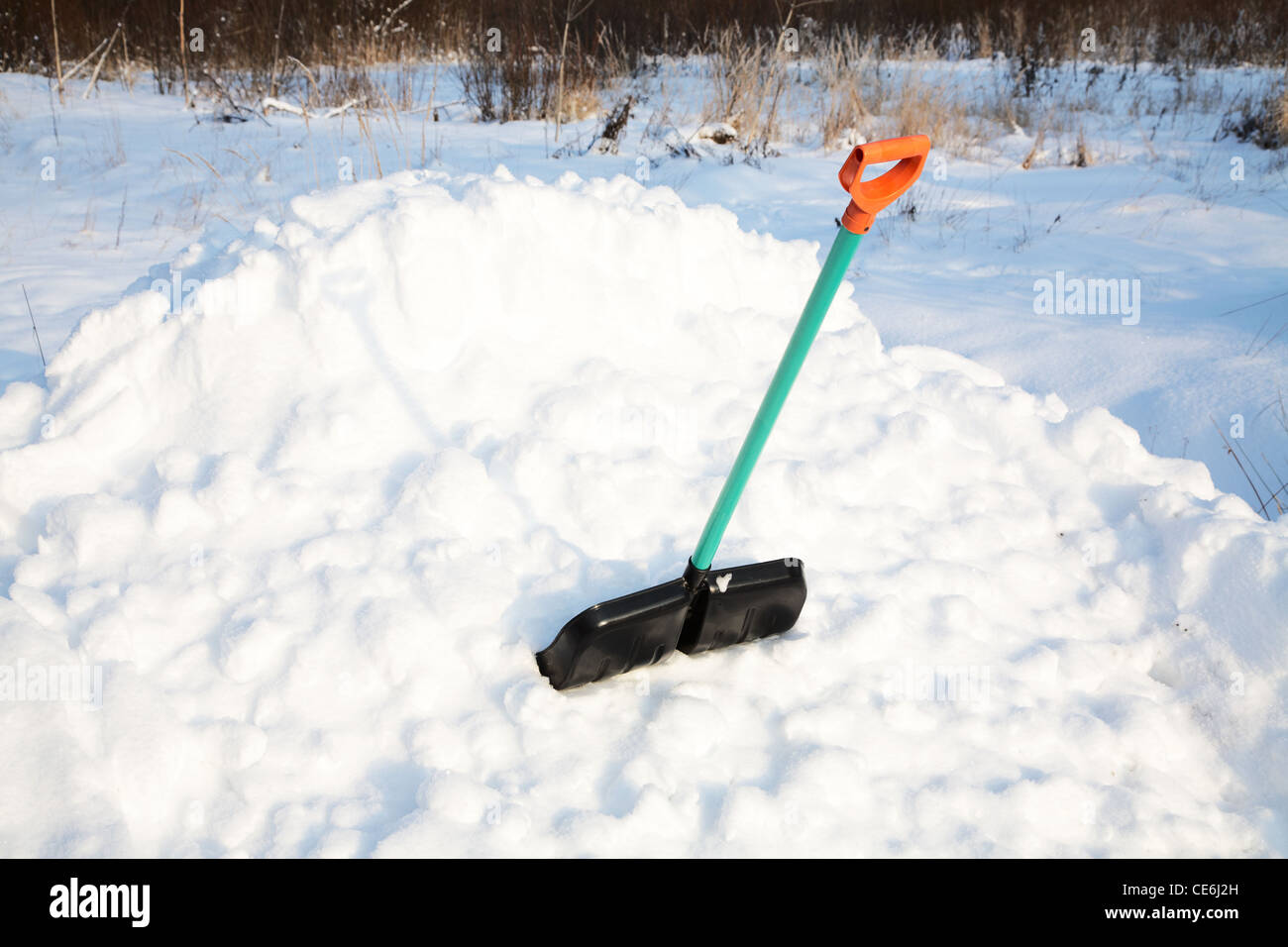shovel for snow cleaning sticks out in a snowdrift in the winter afternoon Stock Photo