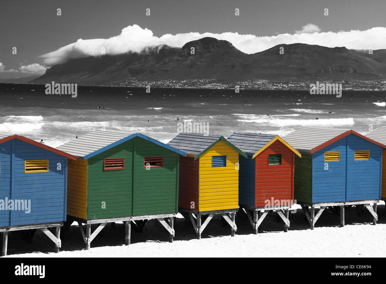 Beach huts with Black and White mountain backdrop and ocean with strong contrast Stock Photo