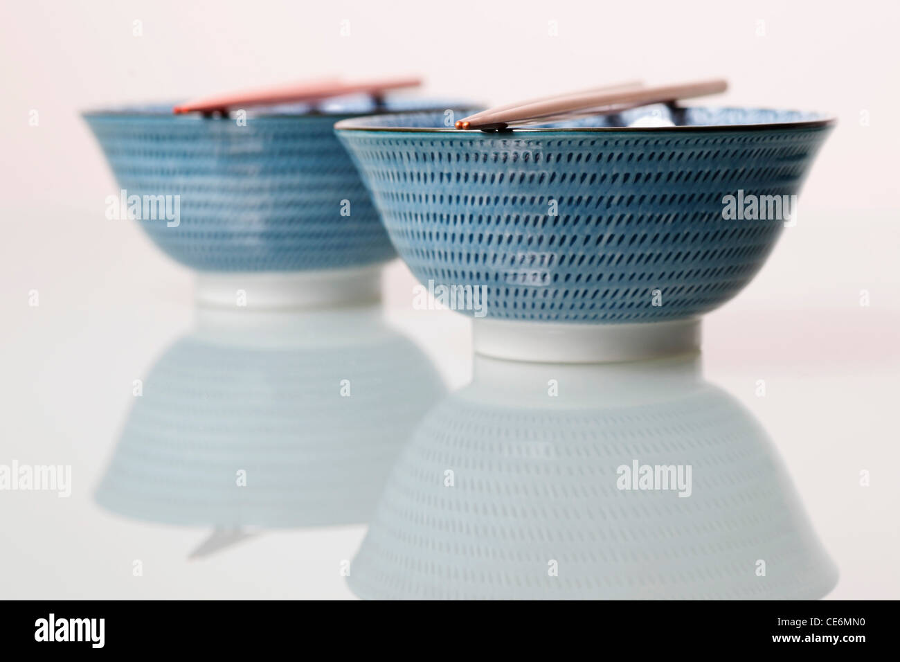 Two China bowls with chopsticks on top Stock Photo Alamy
