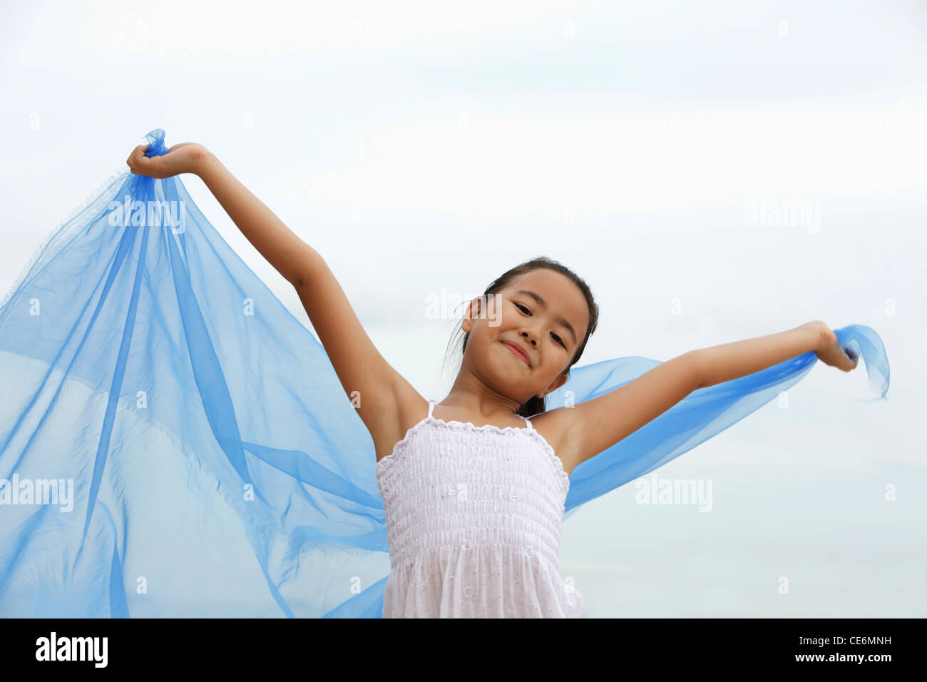 young girl holding blue cloth smiling Stock Photo