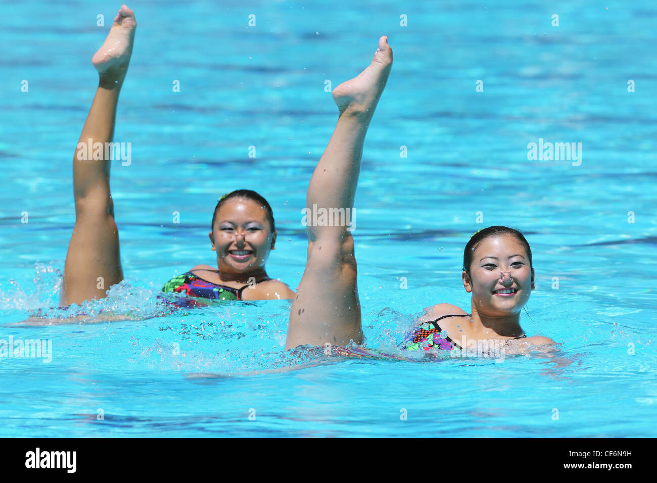 Synchronized Swimmers Performing in Swimming Pool Stock Photo