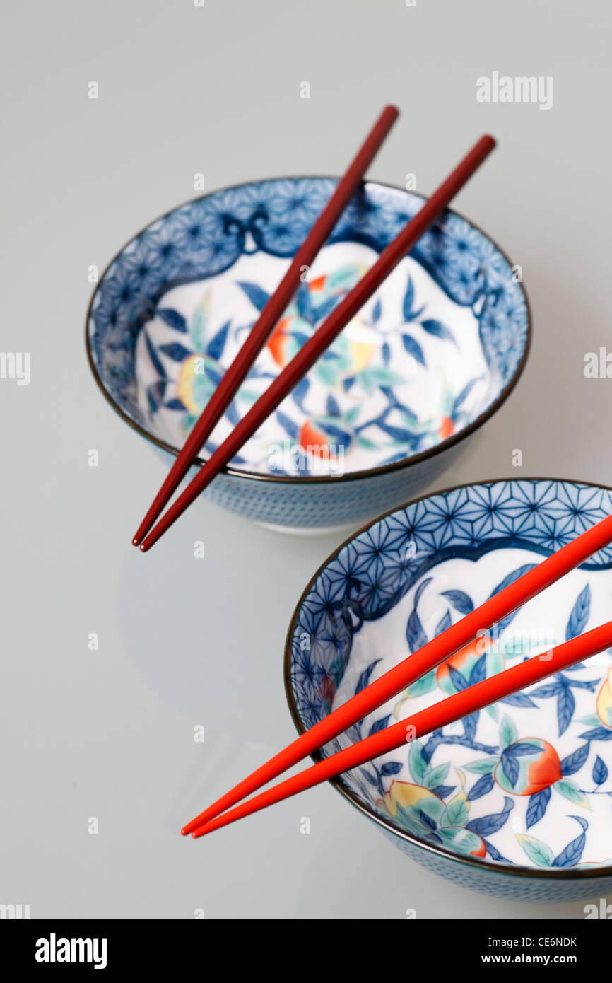 Two China bowls with chopsticks on top Stock Photo Alamy