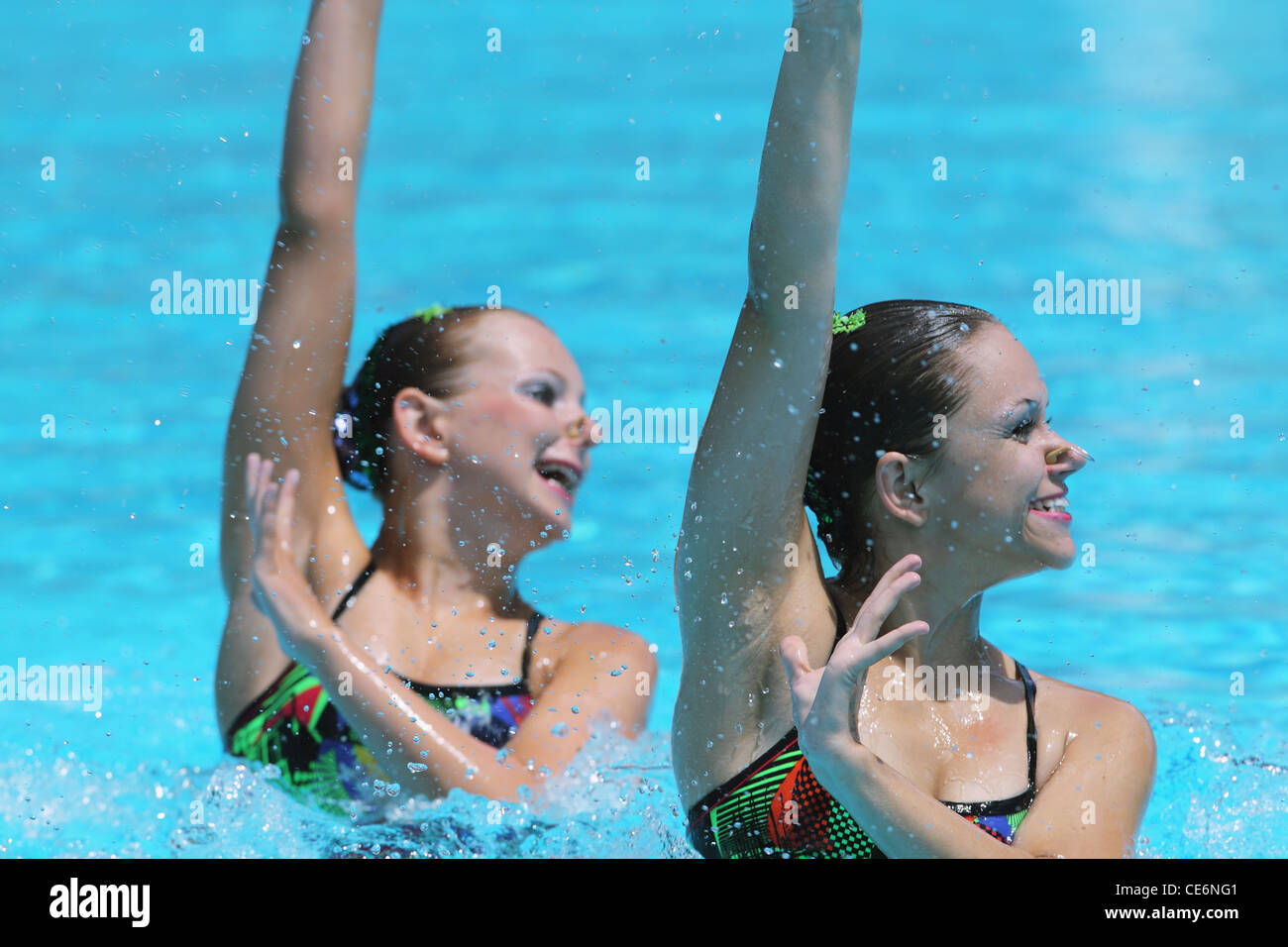 Synchronized Swimmers Performing in Swimming Pool Stock Photo