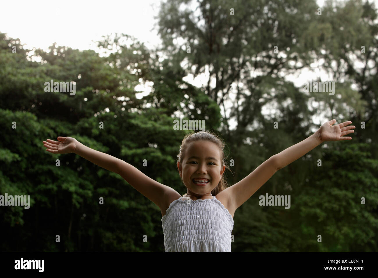 young girl with ams outstretched smiling at camera Stock Photo