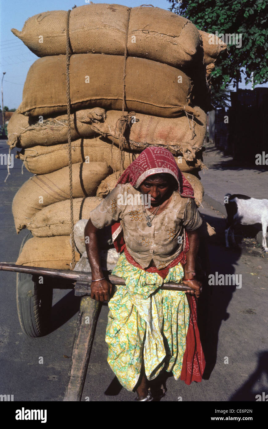 Woman pulling cart ; street scene ; Ahmadabad ; Gujarat ; India Stock