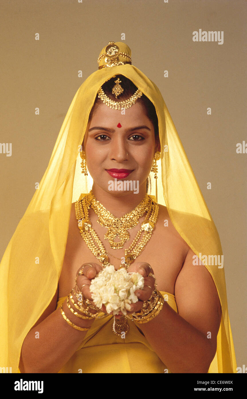 DAC 85217 : woman wearing gold jewellery necklace bangles earrings forehead jewelry offering white mogra flowers india Stock Photo