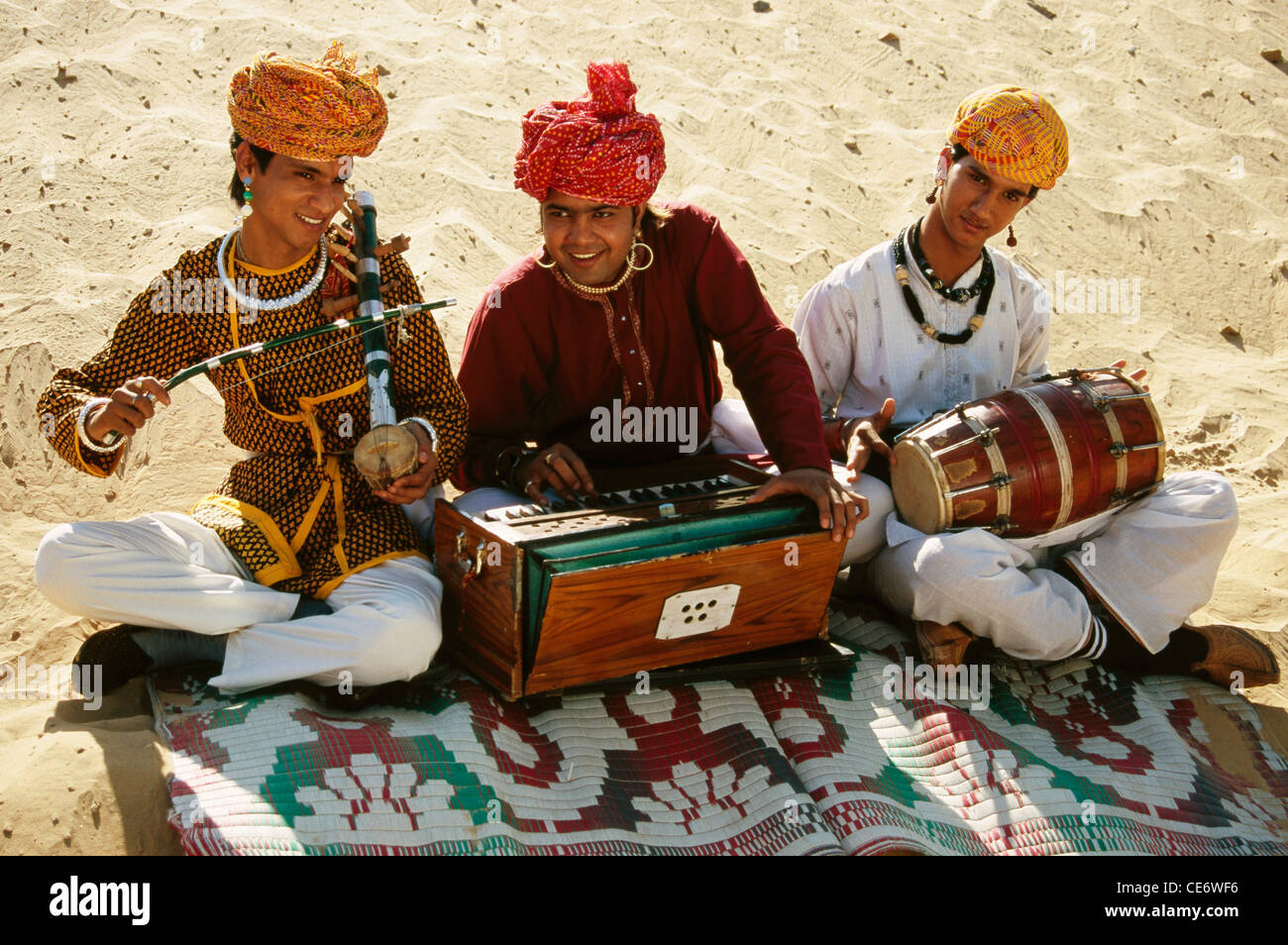 BDR 83396 : rajasthani folk musicians playing musical instrument harmonium violin drum in desert rajasthan india MR#657A Stock Photo