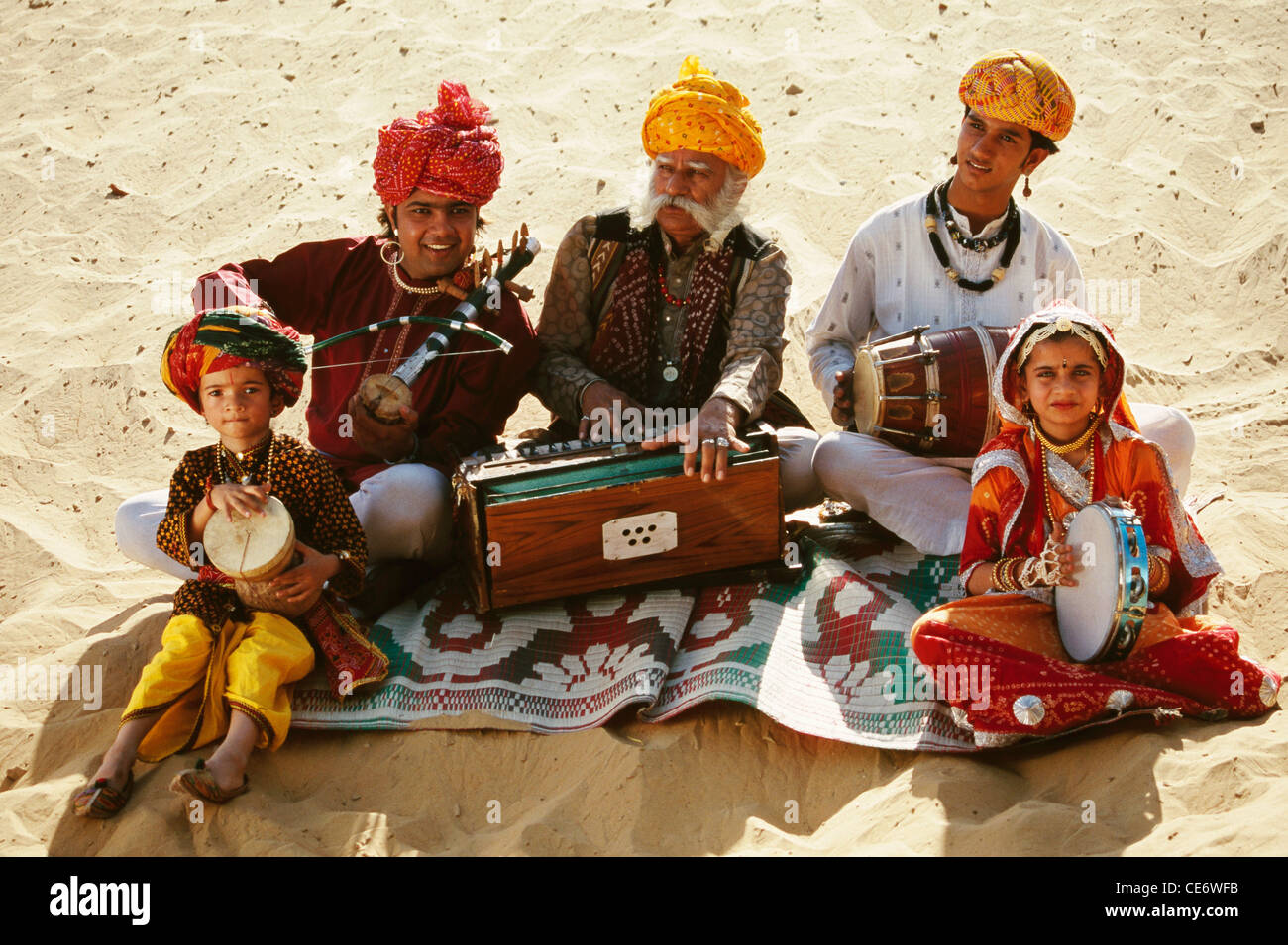 BDR 83398 : rajasthani folk musicians family playing harmonium violin drums in desert sand rajasthan india  MR#657B Stock Photo