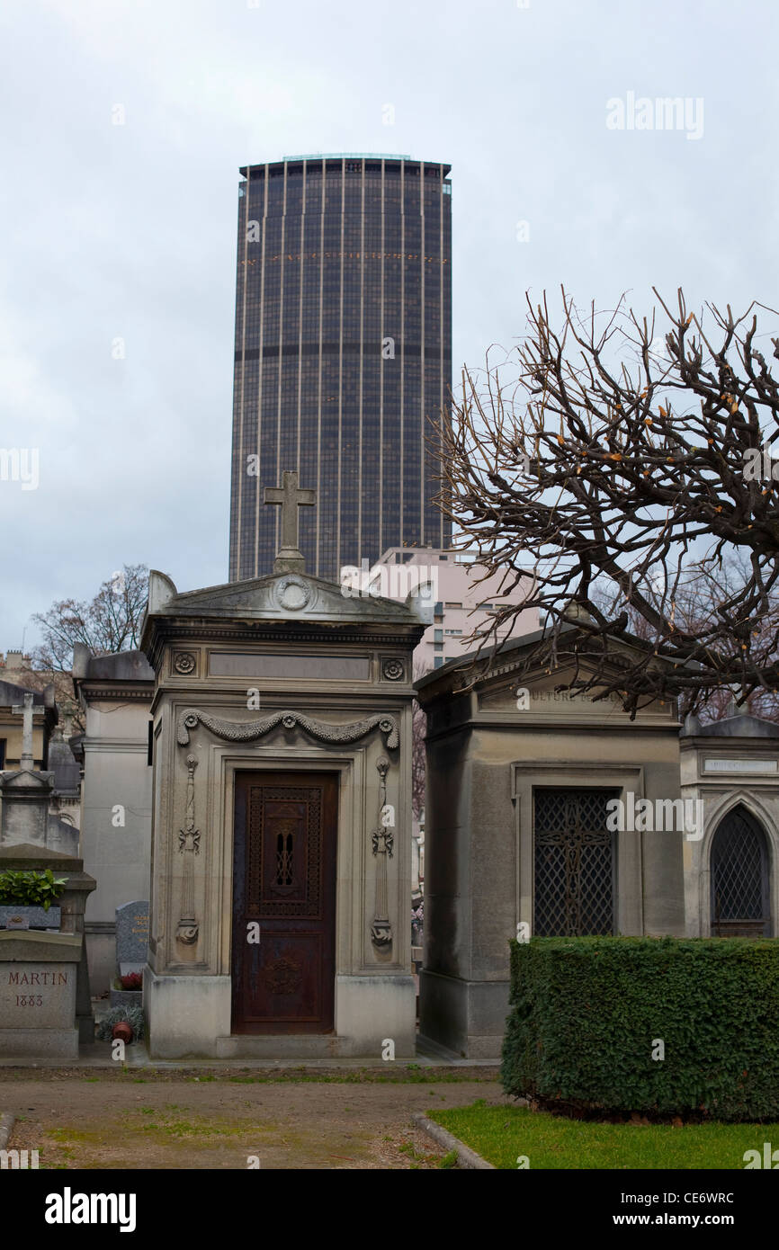 A tomb in Montparnasse Cemetery, Paris, with Montparnasse Tower behind Stock Photo