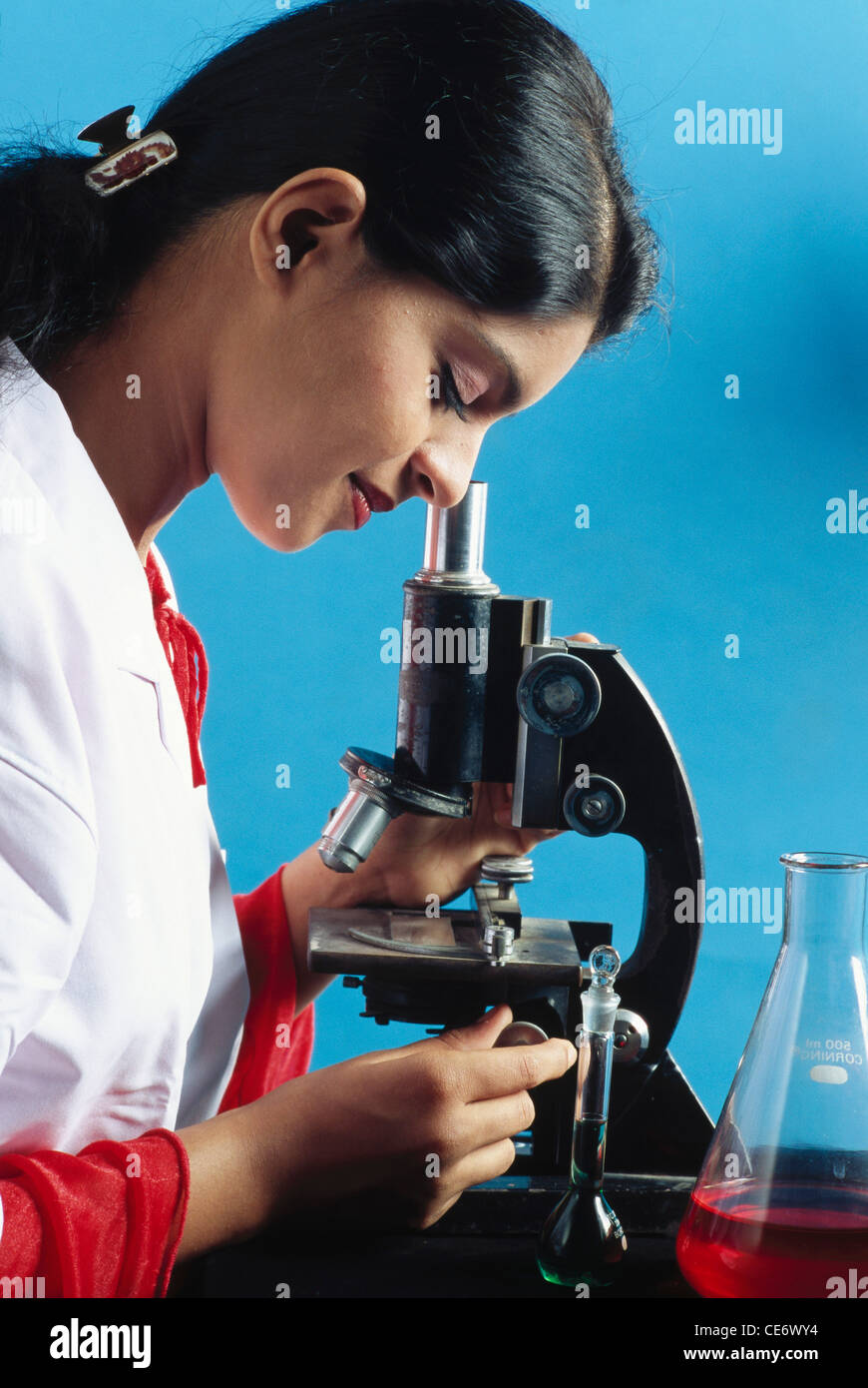 RMM 85320 woman lab technician looking through microscope doing