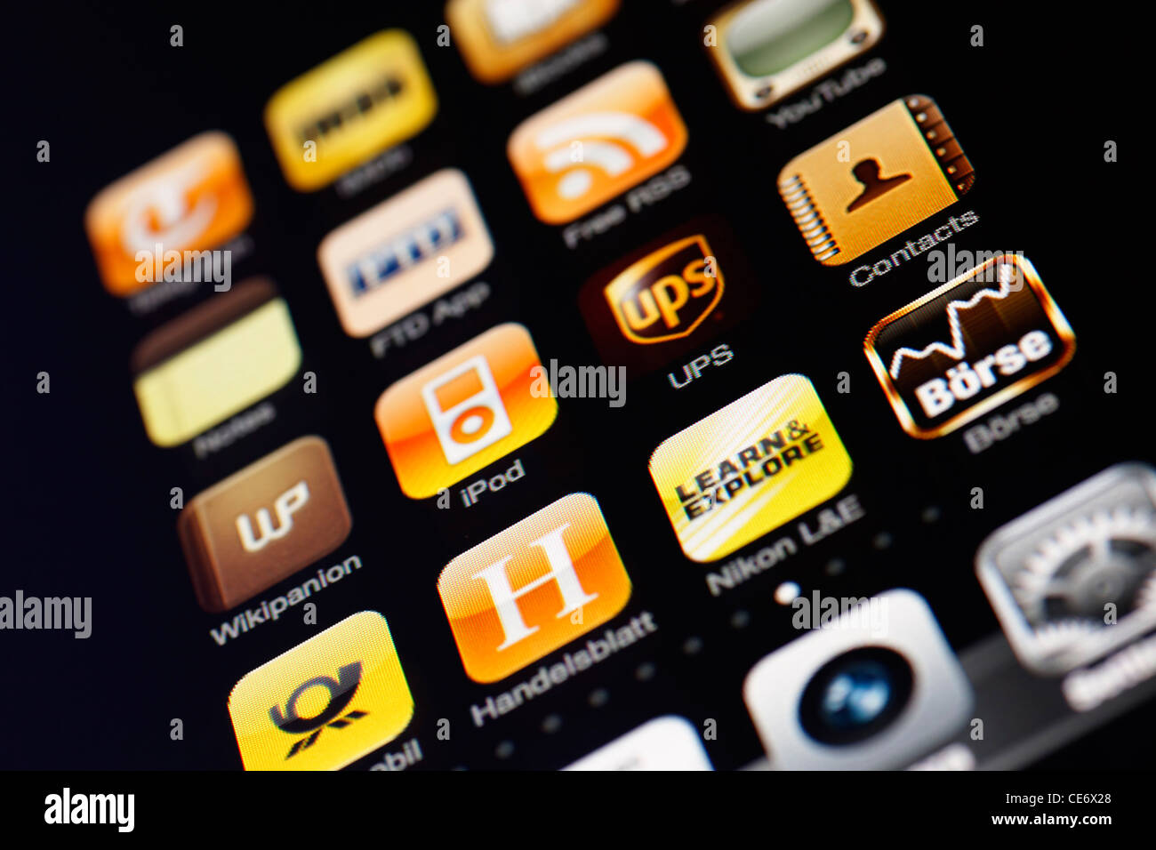 Muenster, Germany, January 26, 2012: Image of the iphone touch screen. Display shows a collection of useful apps with yellow col Stock Photo