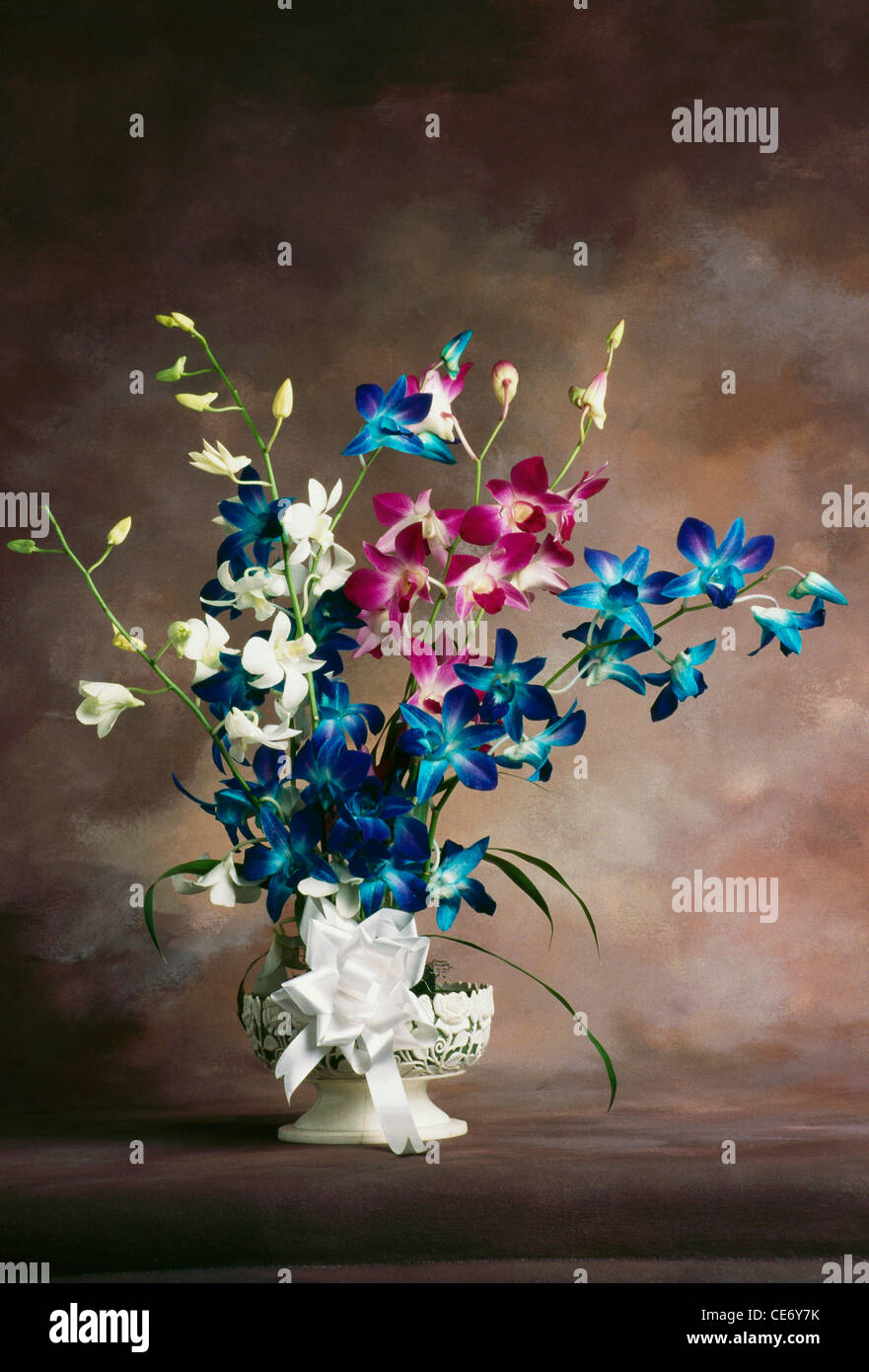 Artificial flowers arrangement of Orchids flower in a vase Stock Photo