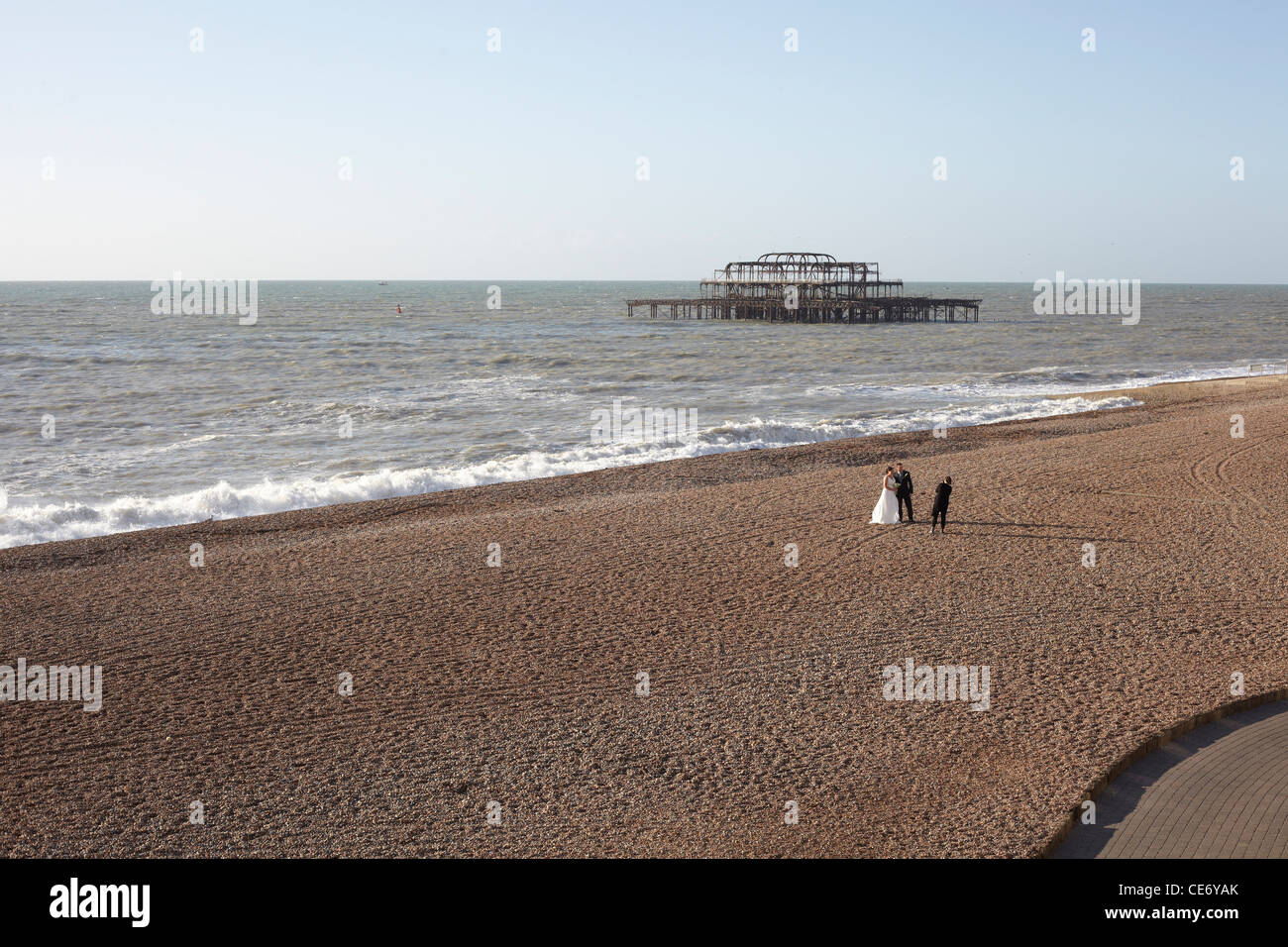 Couple in wedding clothing being photographed on Brighton Beach Stock Photo