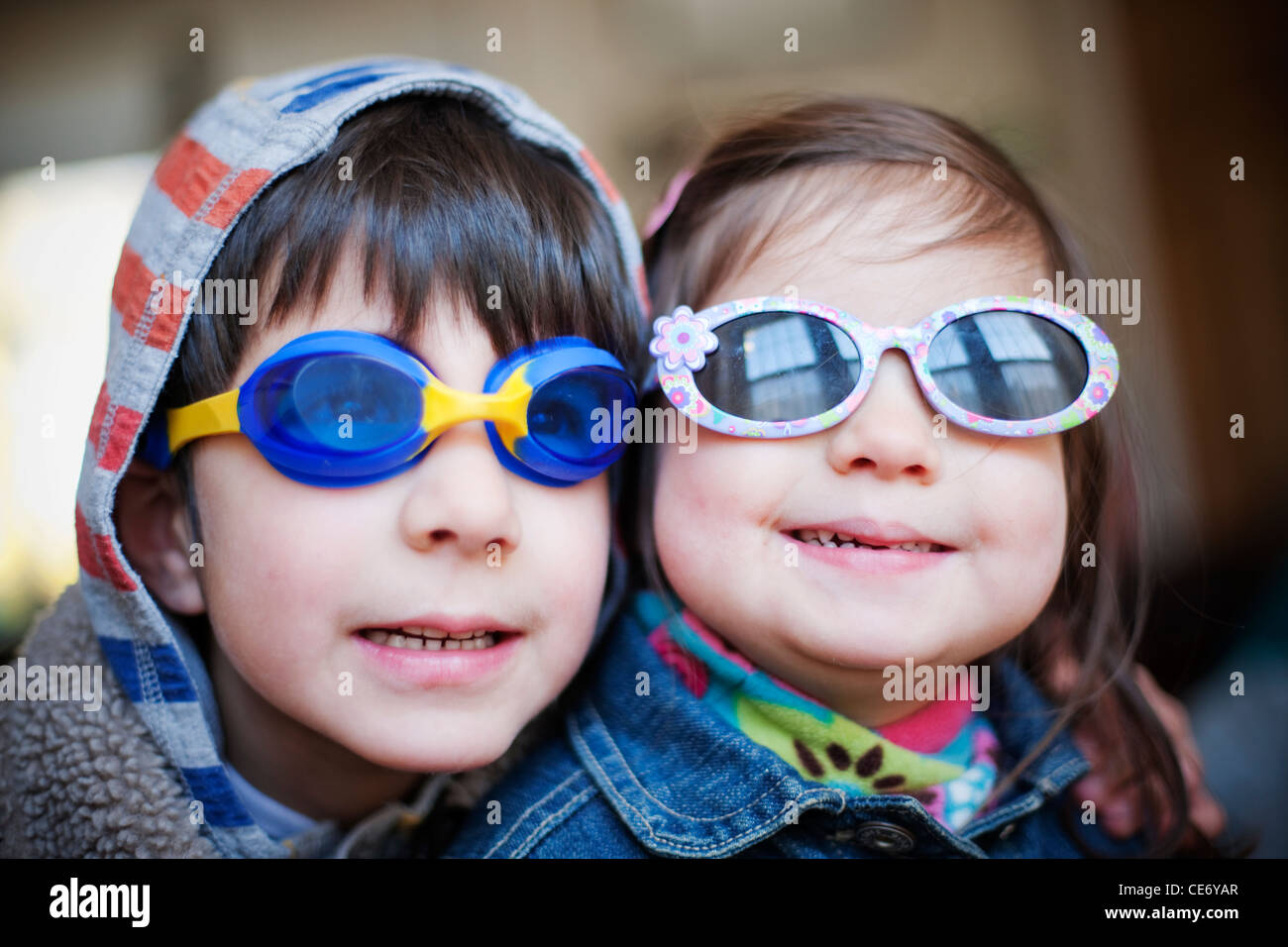Two children wearing swimming goggles and sunglasses Stock Photo