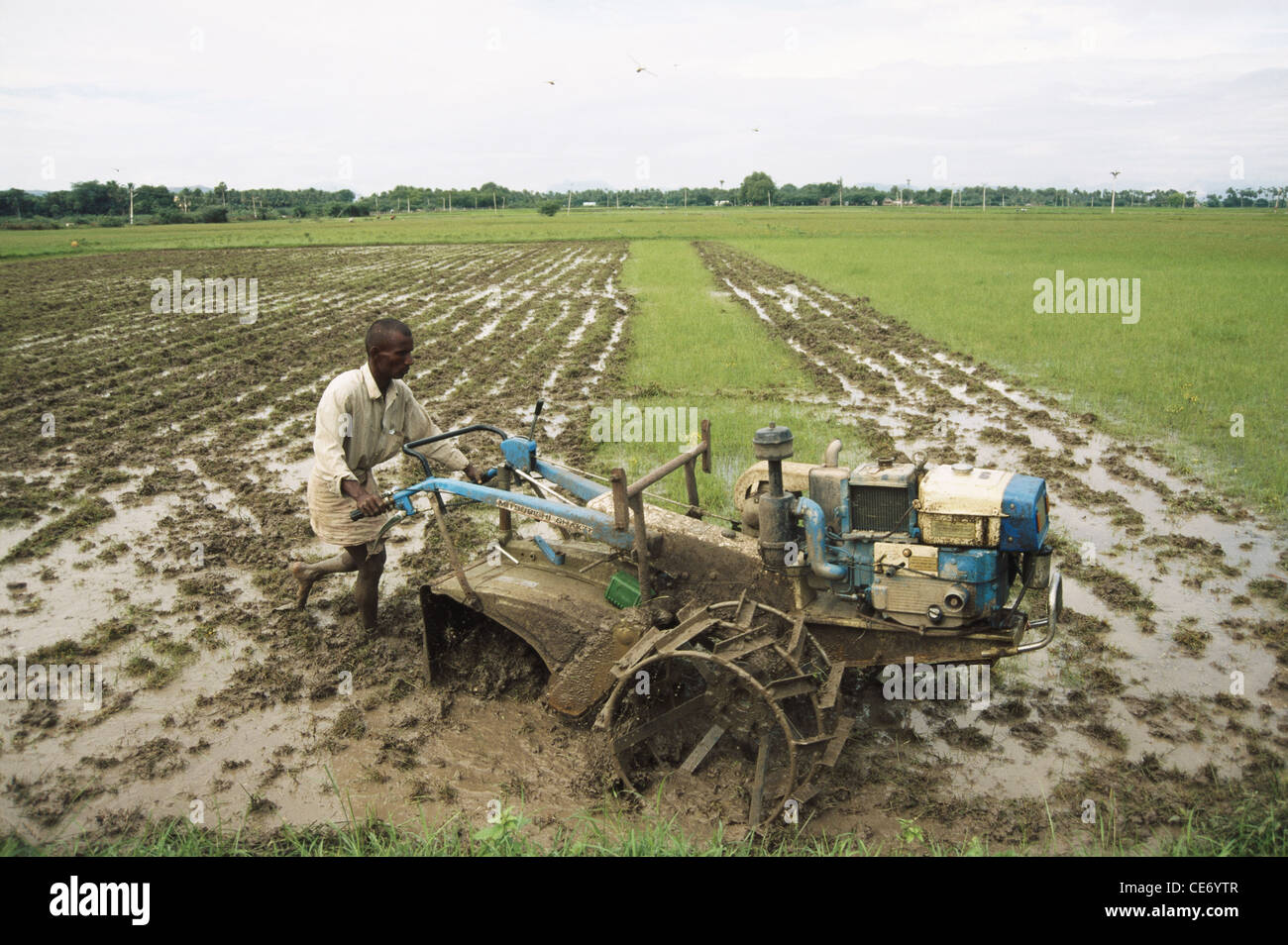 Indian farmer ploughing field with machine tamilnadu india Stock Photo