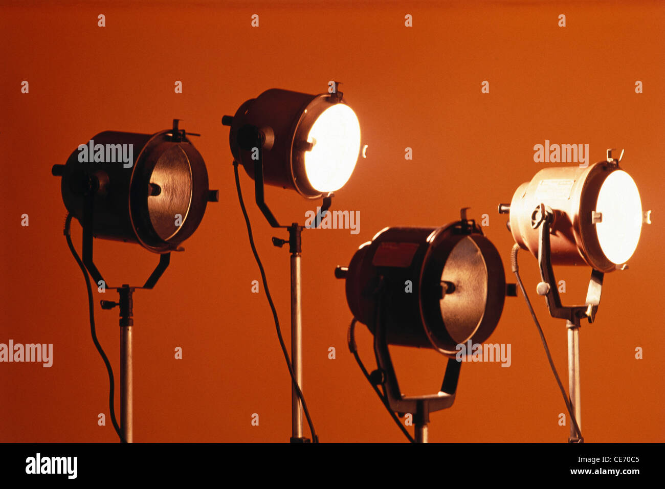Four studio lights two on two off orange background Stock Photo