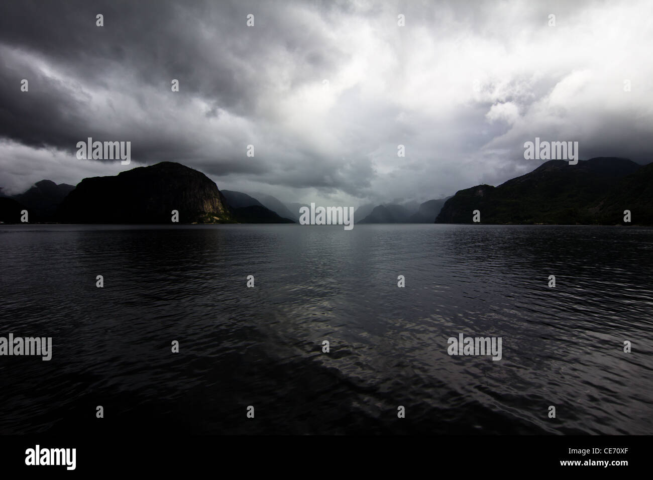 View over fjord in Norway, Europe, with clouded skies and dark mountains Stock Photo