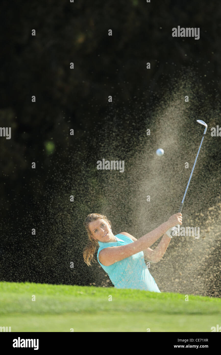 Female Golfer Playing Bunker Shot Stock Photo