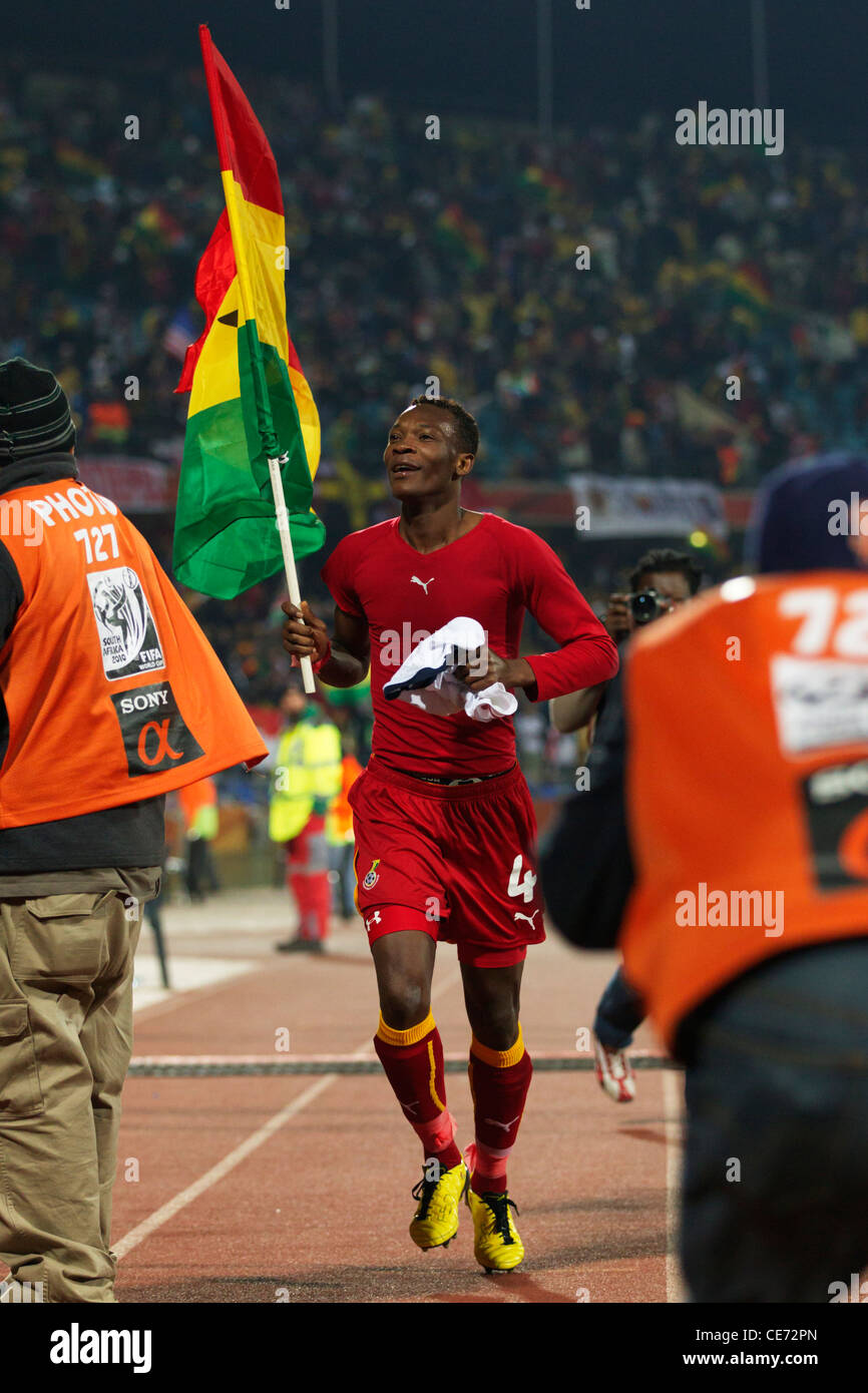 John Pantsil of Ghana carries the national flag after Ghana defeated the USA in a 2010 FIFA World Cup round of 16 match. Stock Photo