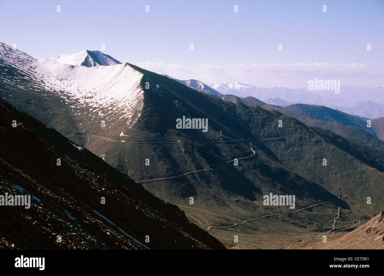 SDM 83038 : road cutting through snow top indian mountain at khardung in leh ladakh jammu and kashmir india Stock Photo