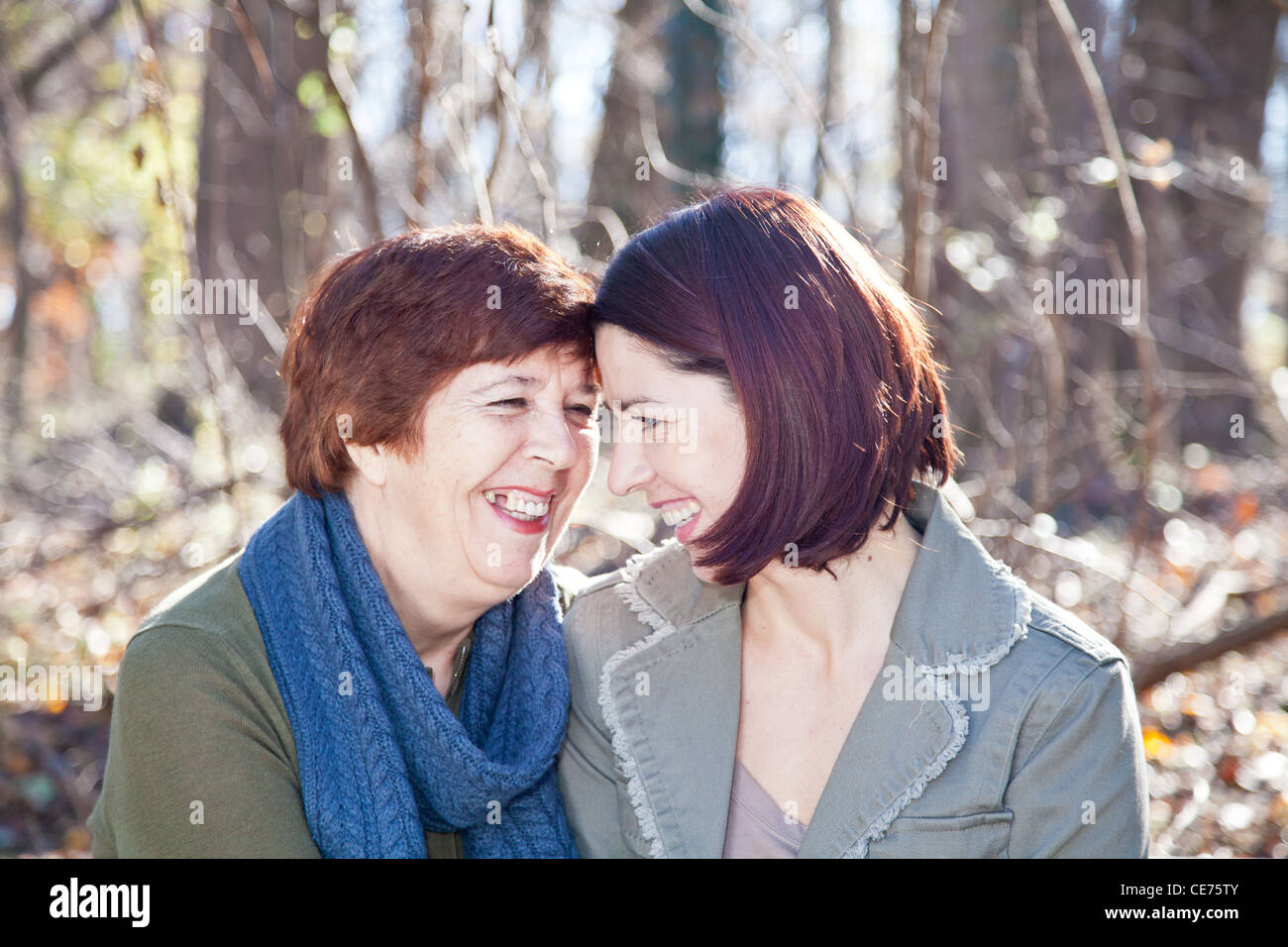 Intimate portrait of women (mother and daughter) laughing at each other ...