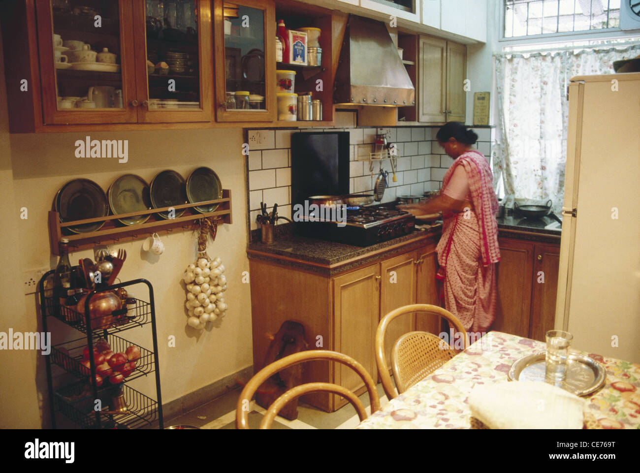Indian kitchen ; woman cooking in higher middle class family kitchen