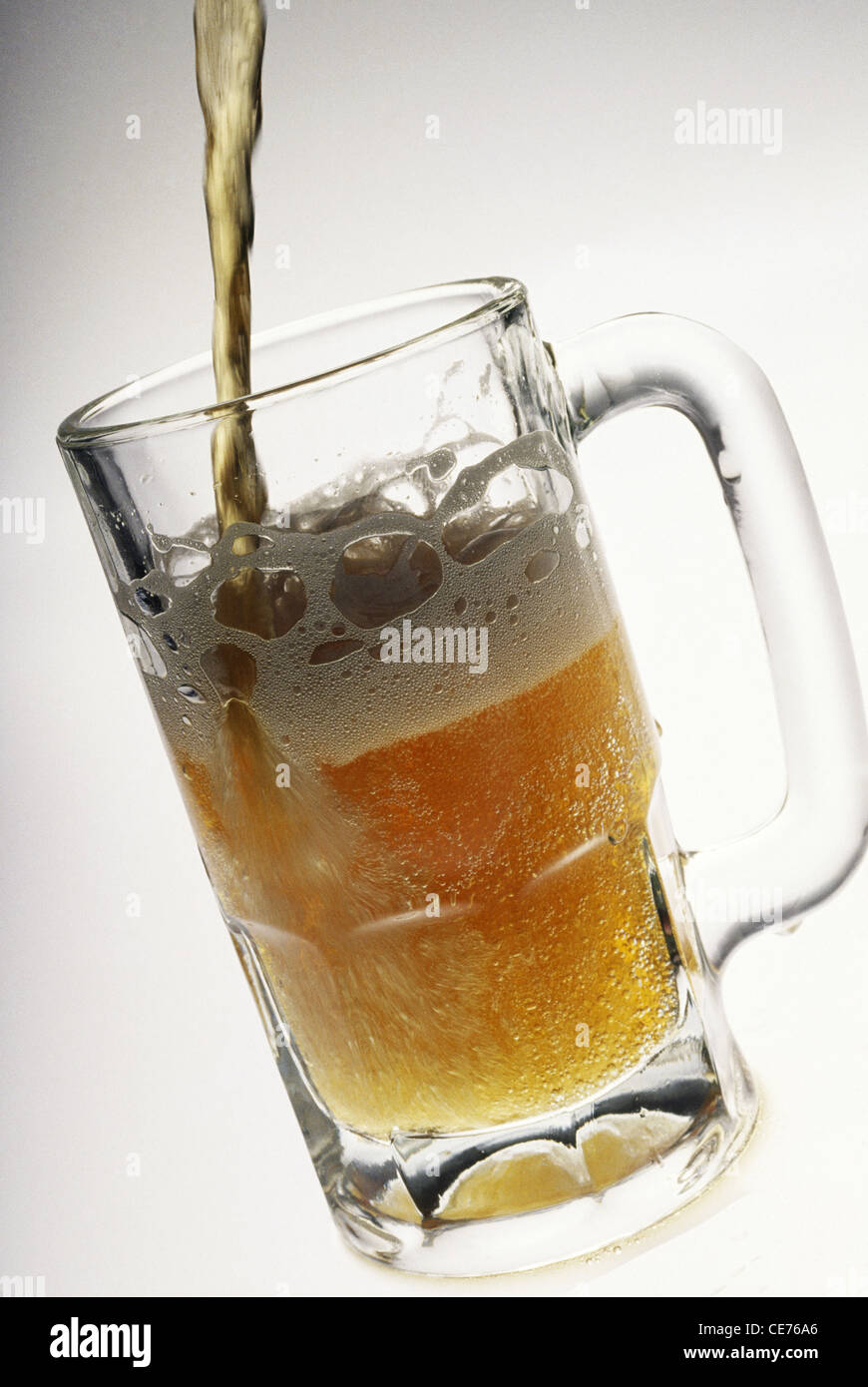 Pouring Beer in mug transparent glass on white background Stock Photo