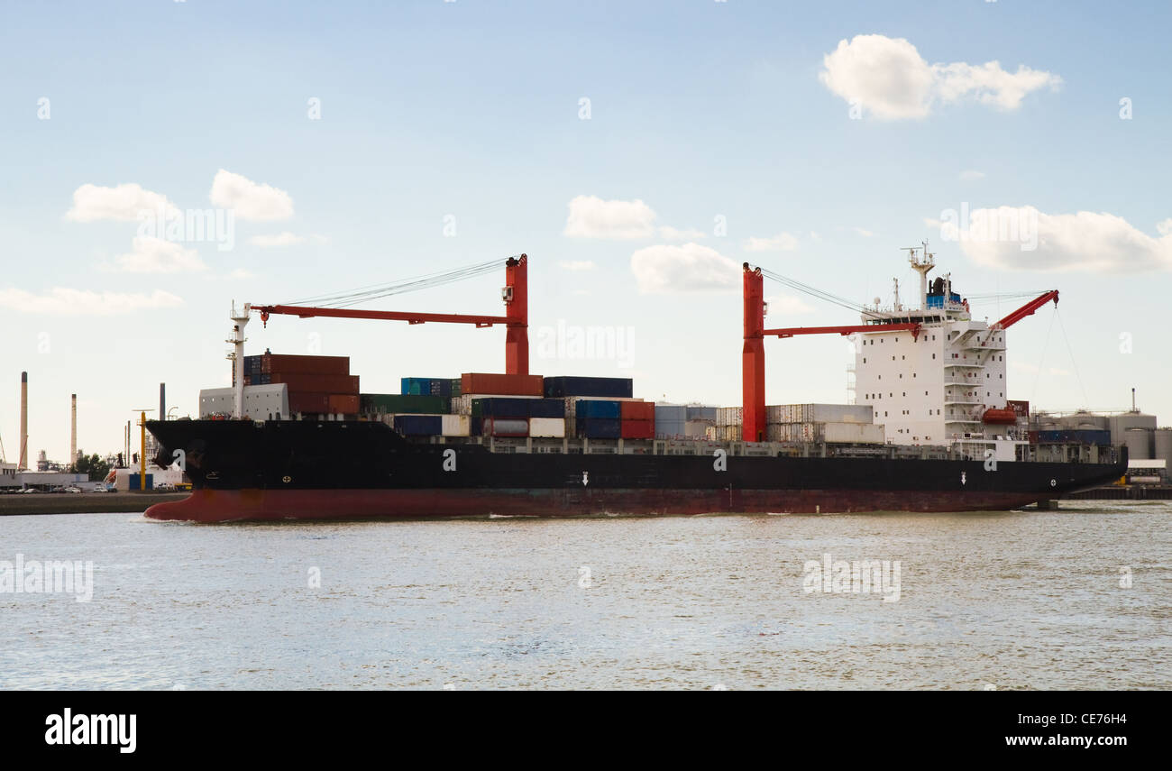 Big container ship with onboard cranes on the river coming in to port Stock Photo
