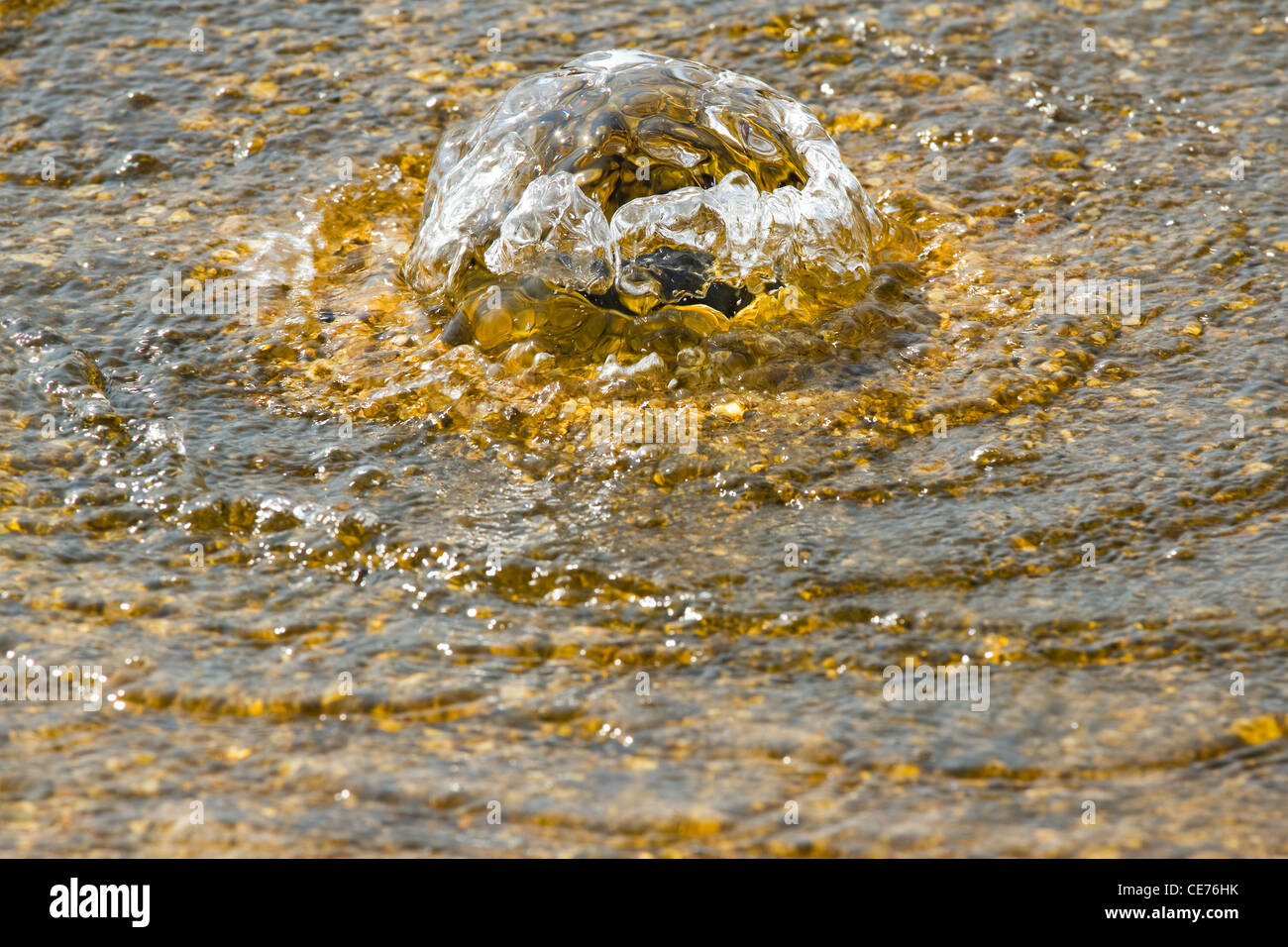 Golden water flowing and bubbling in summer sunshine - spa and relax concept Stock Photo