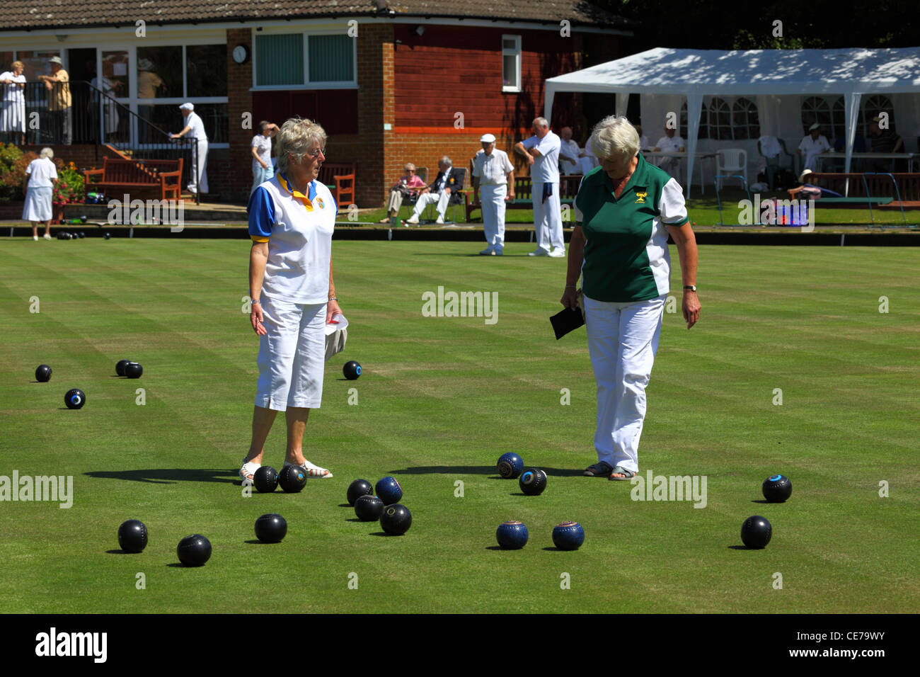 Women check position of woods during a game of bowls , Southborough Common , Tunbridge Wells , Kent , England Stock Photo