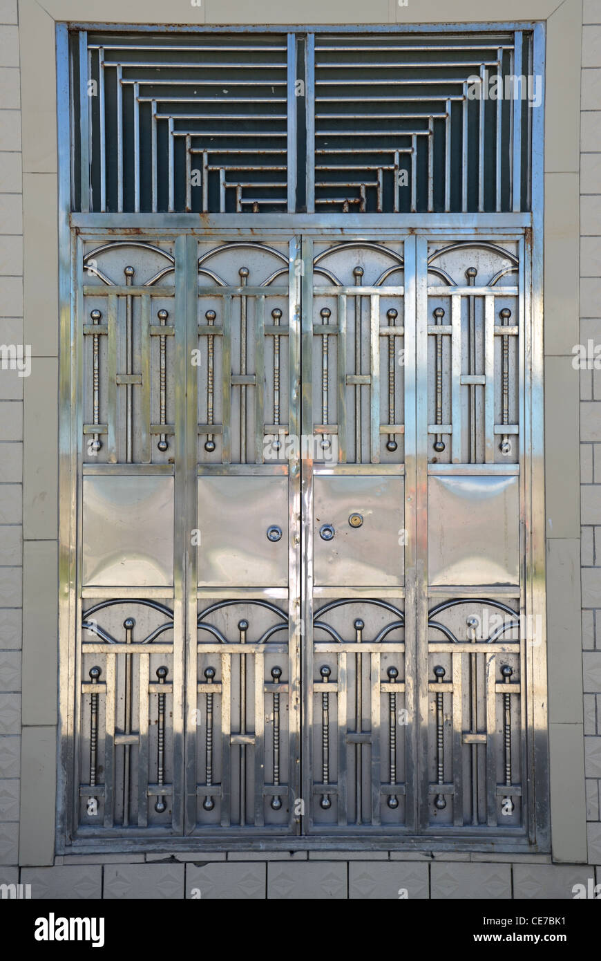 Decorative mixed style double door gate in polished metal Stock Photo